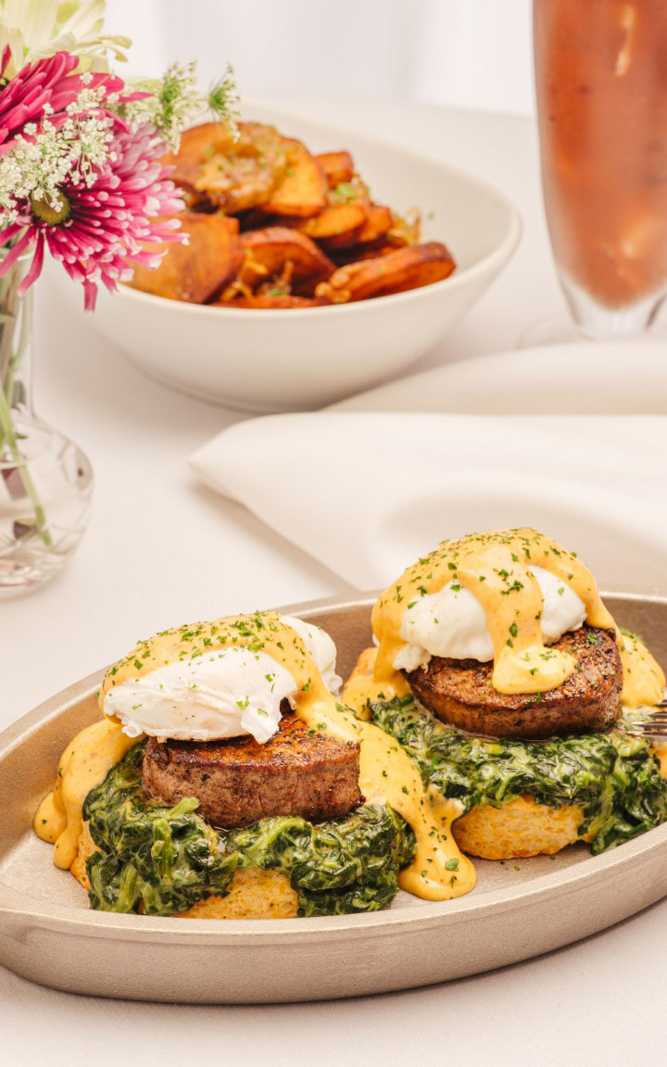 Ruth Chris's Cajun Tenderloin Eggs Benedict. Blackened filet, creamed spinach, cheddar biscuit, poached eggs, and hollandaise.