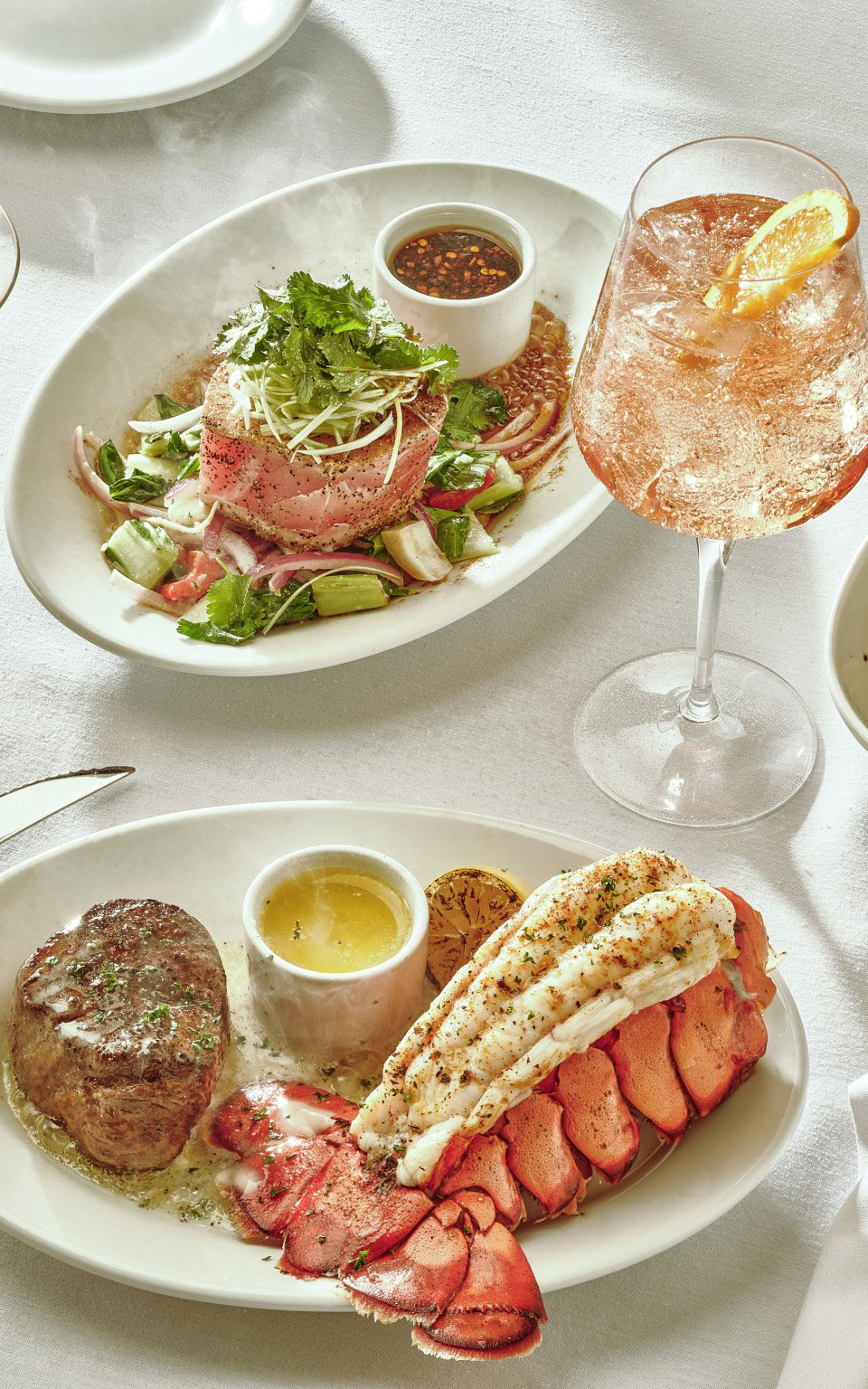 Ruth's Chris CHEF’S SUMMER SELECTIONS. All items served: Cucumber Gin Martini, Elderflower Spritz, Chandon Spritz, Ahi Tuna Mignon, and Center-Cut Filet with Jumbo Lobster Tail all served on the table.